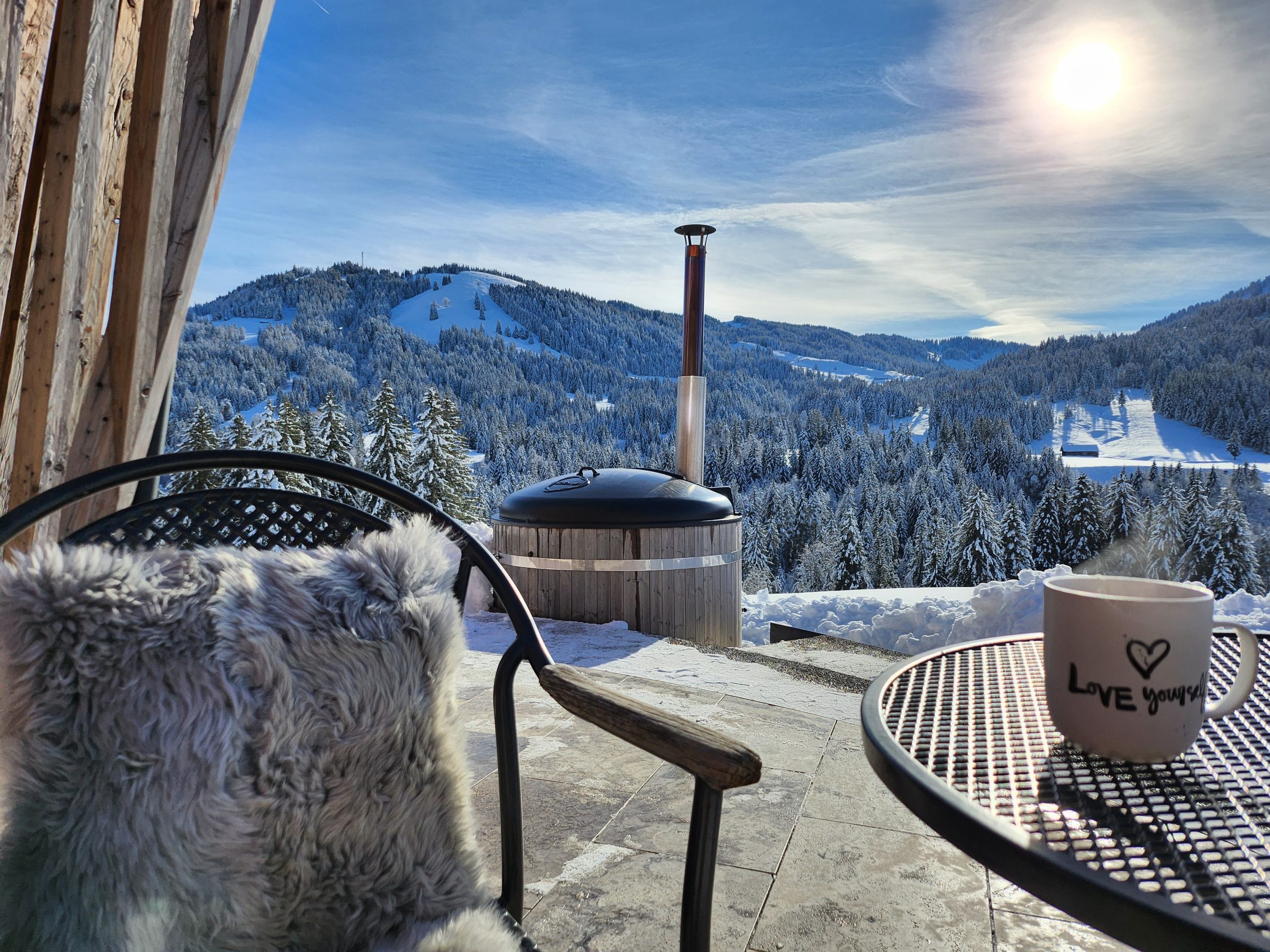 Hot Tub auf der Terrasse im Schnee mit Blick auf die verschneiten Berge