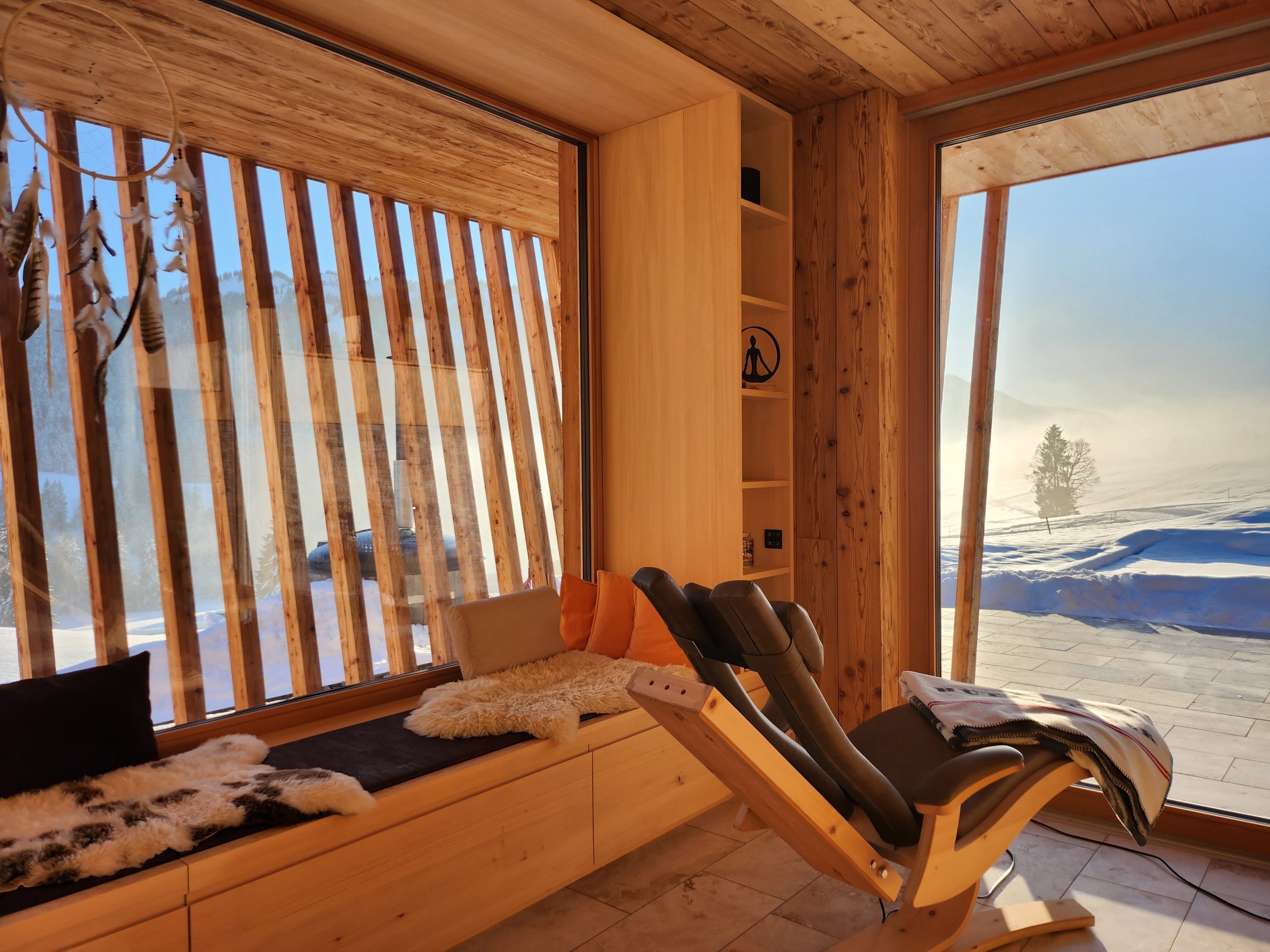 Ruheliegen im Traumraum vor dem Panoramafenster mit Winterlandschaft