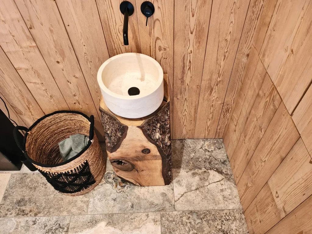 Wellness-Dusche mit Holzeimer und Steinwaschbecken
