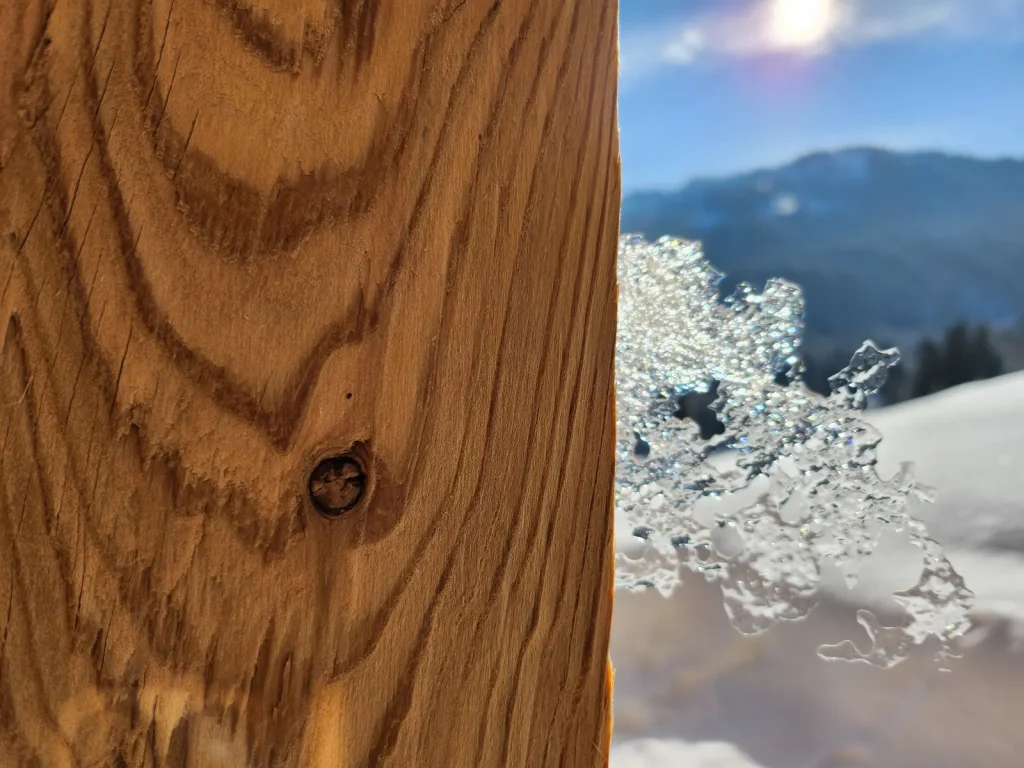 Eiskristall an der Holzfassade des Alpenchalets im Winter