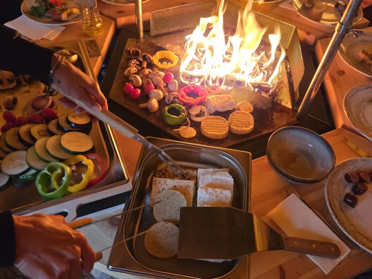 Feuer und Grillgemüse in der Grillkota des Alpenchalets