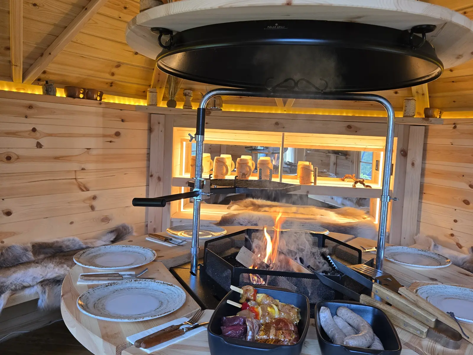 Offenes Feuer in der Grillkota mit gedecktem Tisch