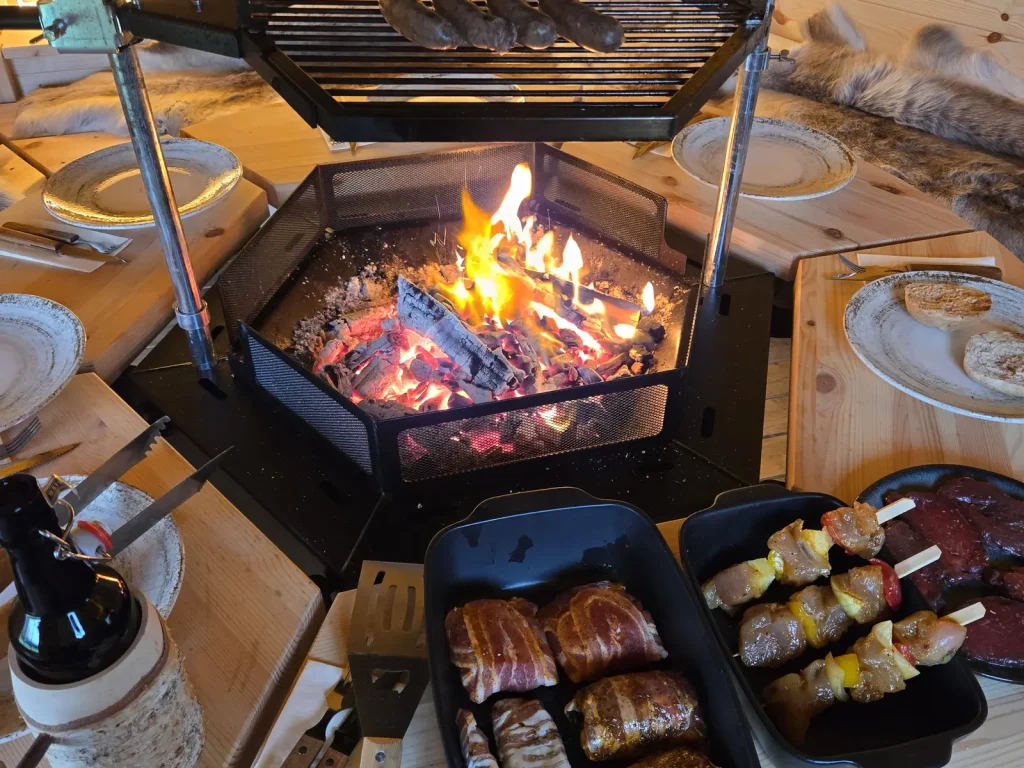 Spieße über dem Feuer in der Grillkota des Alpenchalets