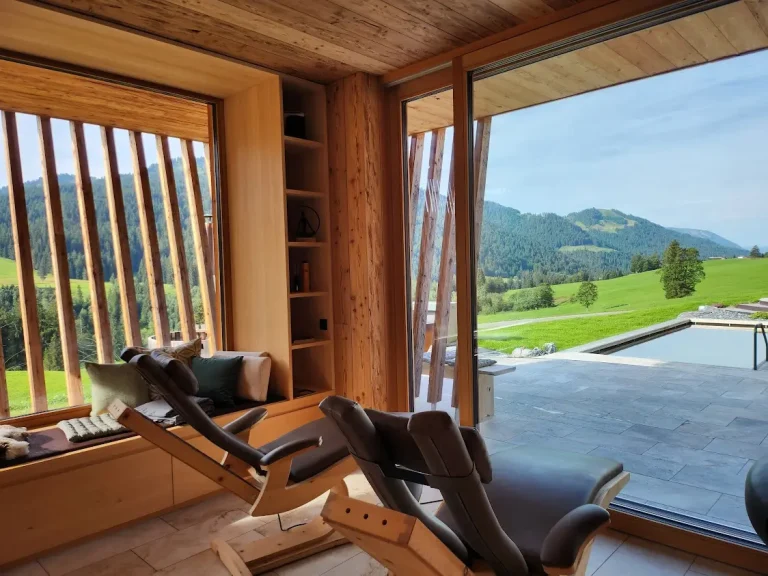 Zwei Infrarotliegen im Traumraum des Alpenchalets mit Blick auf Berge und Pool