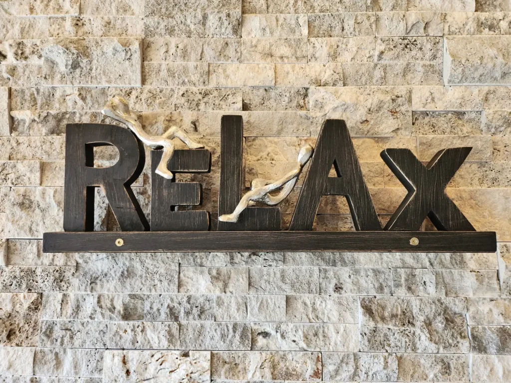 Relax-Schriftzug an der Natursteinwand im Alpenchalet