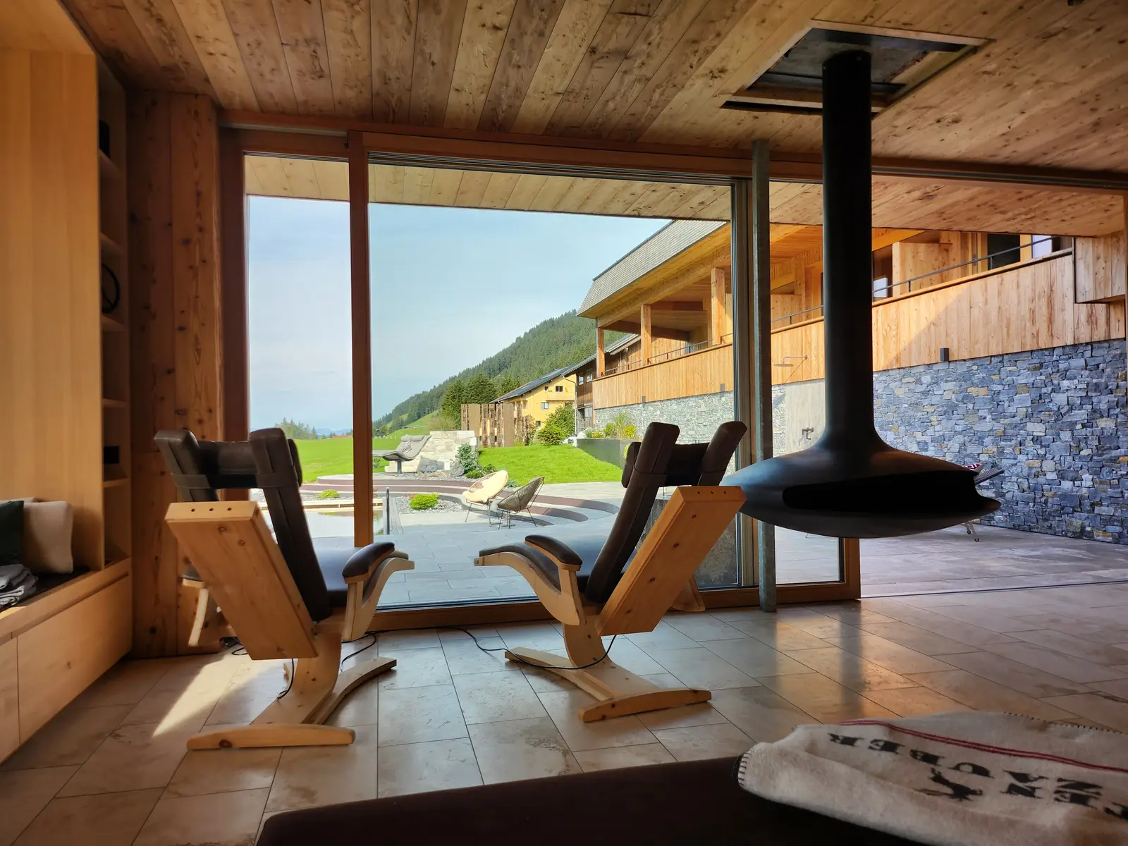 Traumraum mit Ruheliegen, Kaminofen und Blick auf den Garten