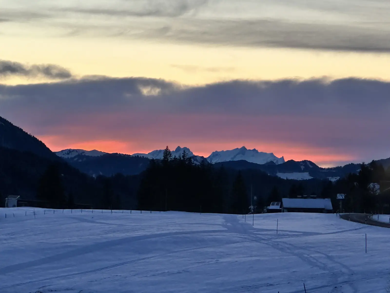 Alpenglühen über dem verschneiten Allgäu am Winterabend