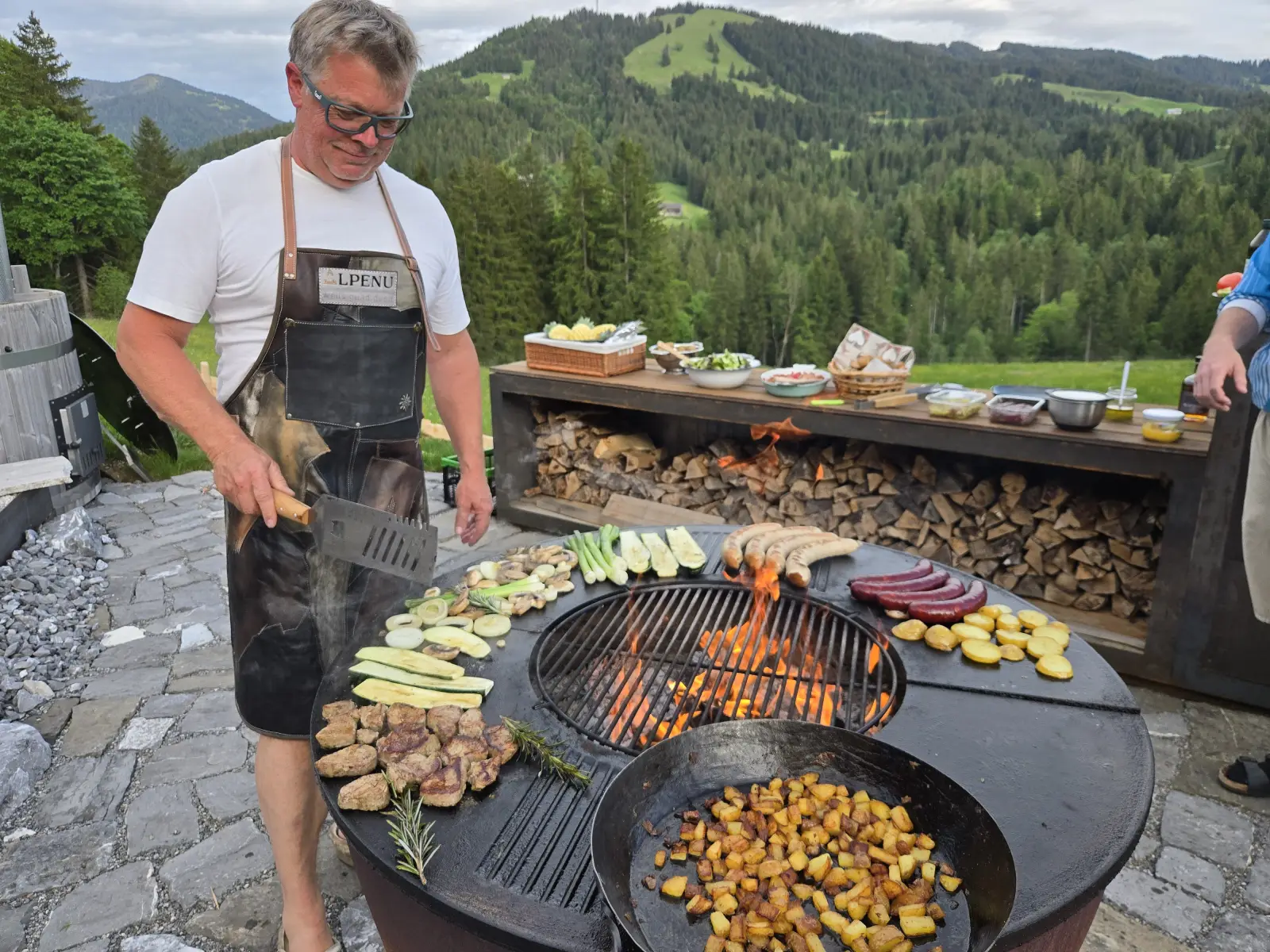 Grillen an der offenen Feuerstelle vor den Bergen