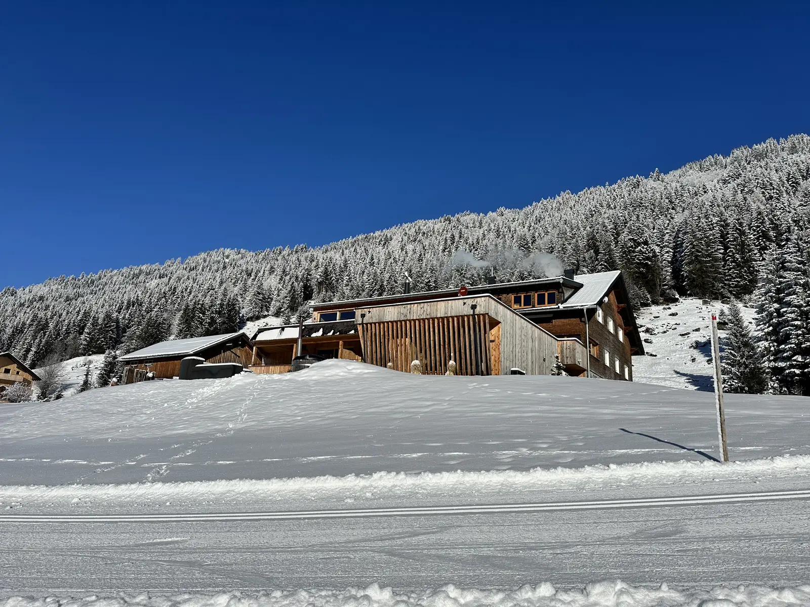 Chalets im Allgäu an der Langlaufloipe im Wintersonnenschein