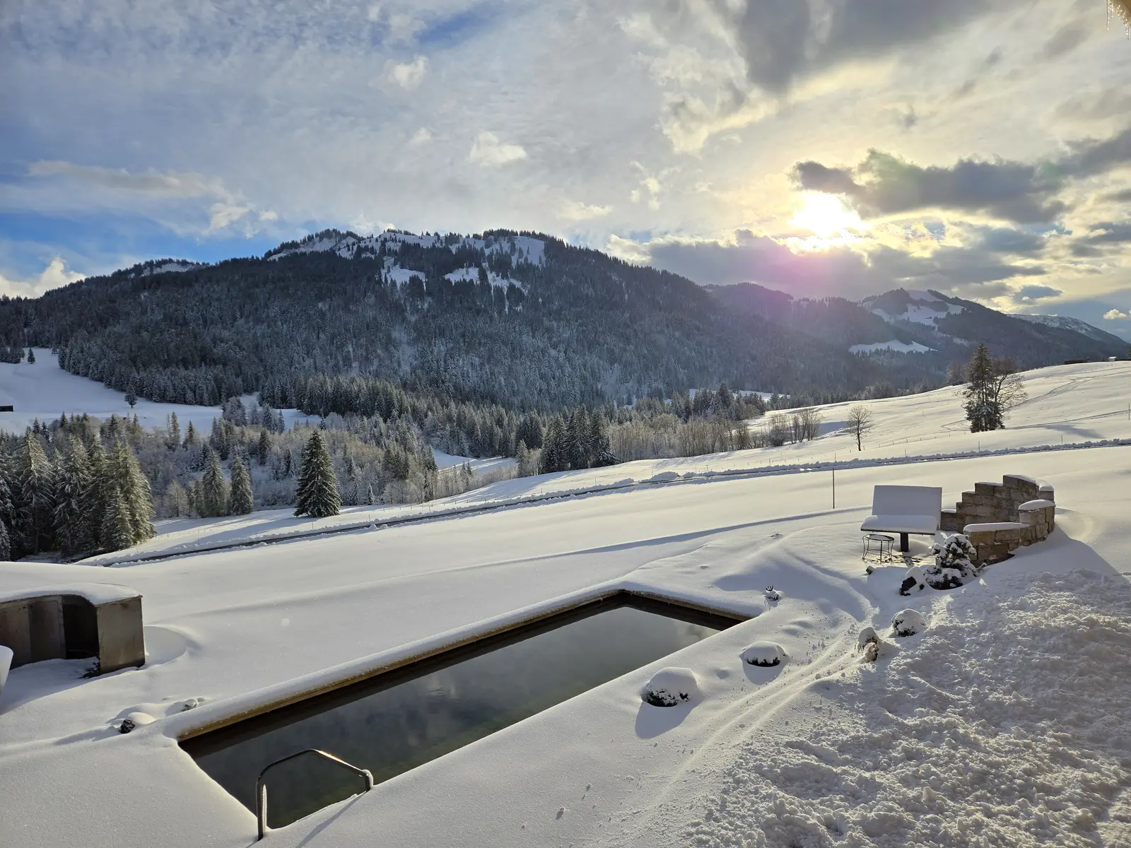 Natur-Pool des Alpenu im Schnee mit Blick über die verschneiten Berge