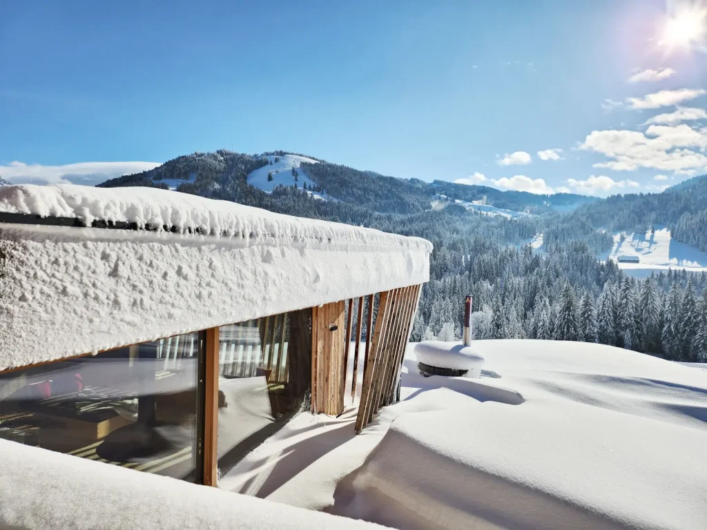 Verschneites Chalet im Allgäu mit Blick auf die Berge