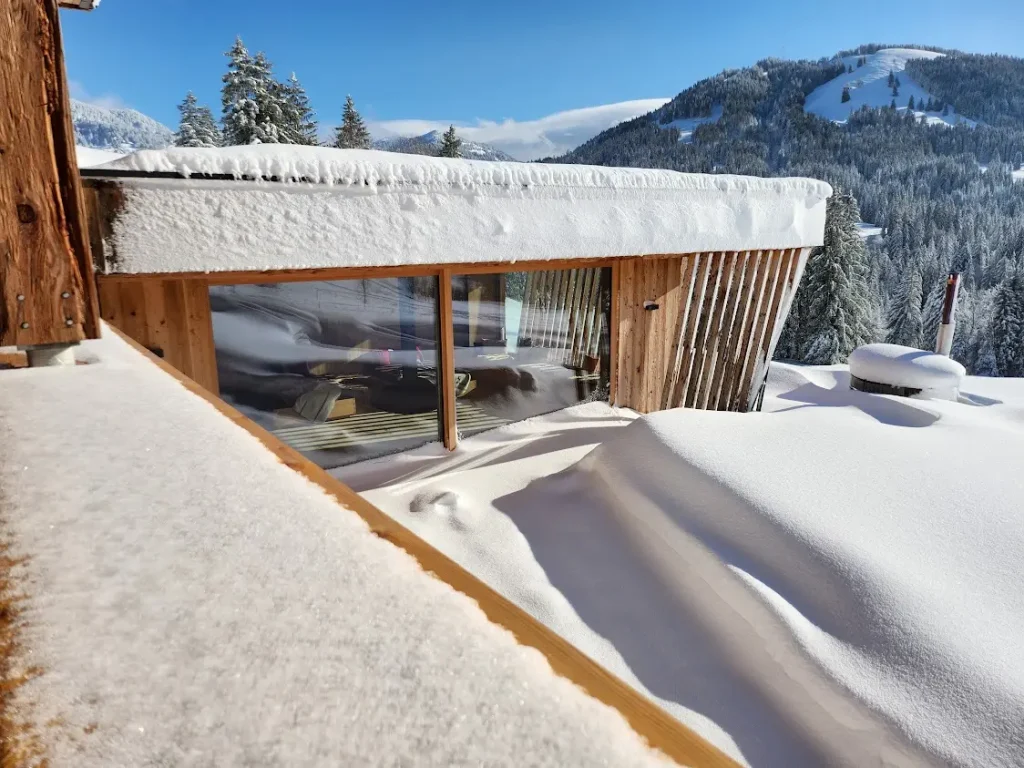 Verschneites Chalet in den Alpen mit Bergblick im Winter